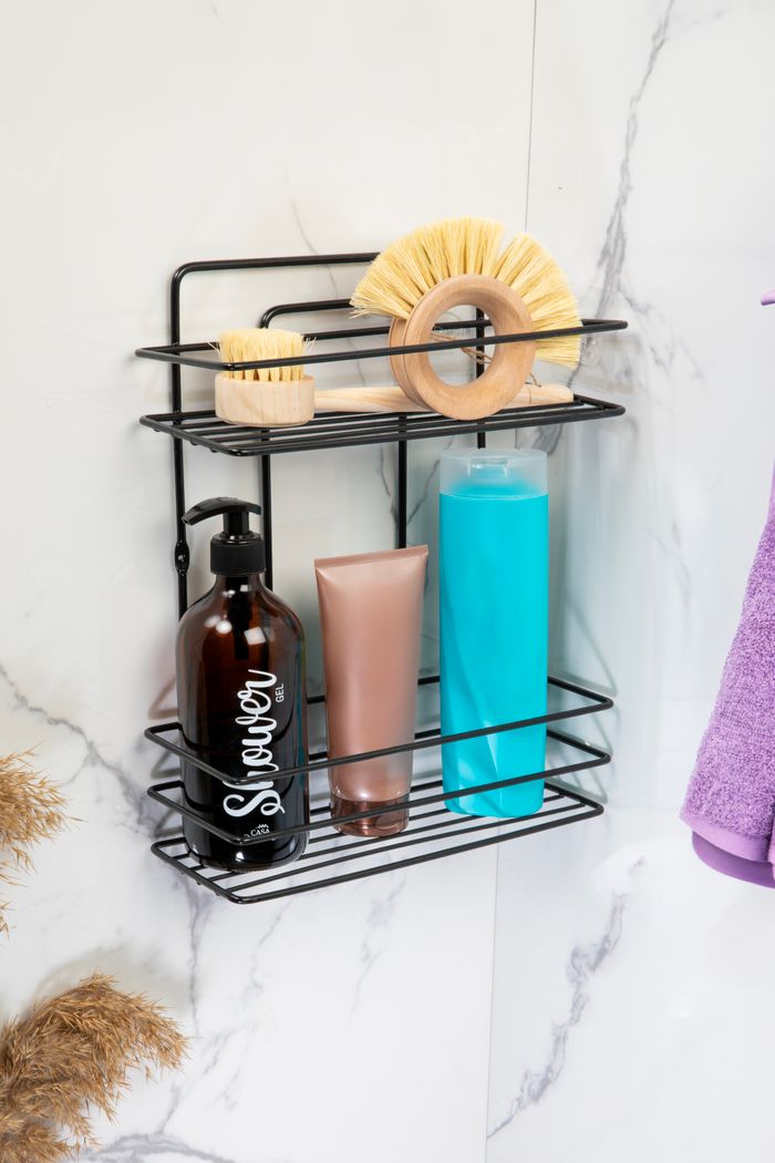 Stylish bathroom rack featuring brushes, shower gel, and shampoo on a marble wall.