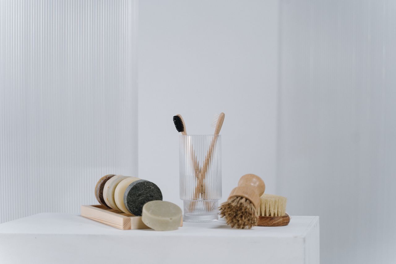 A minimalist arrangement of eco-friendly bathroom essentials including wooden brushes and natural soap bars.